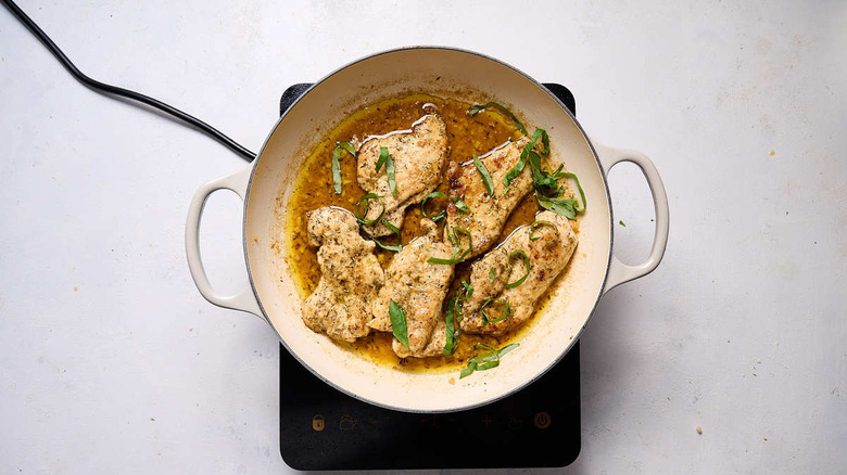 chicken in butter sauce with basil in pan
