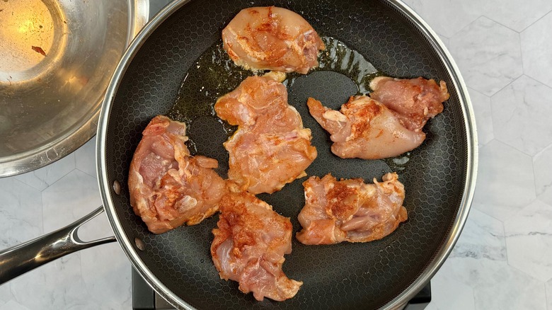 raw chicken in frying pan