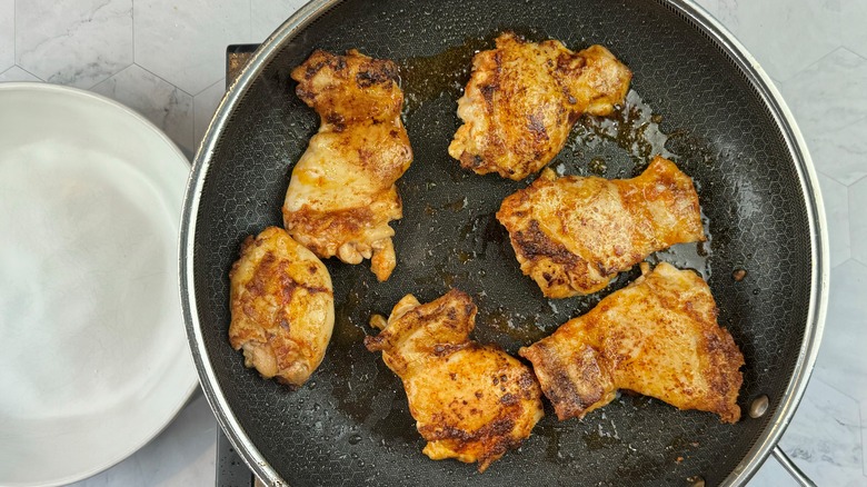 raw chicken in frying pan