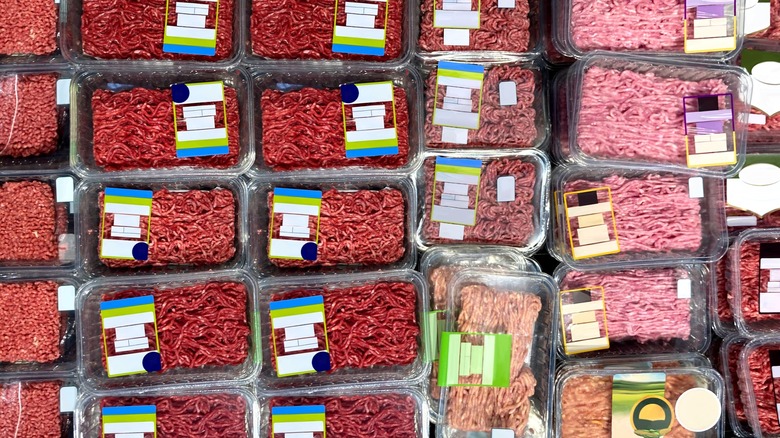 Overview of many different packages of ground beef at a store