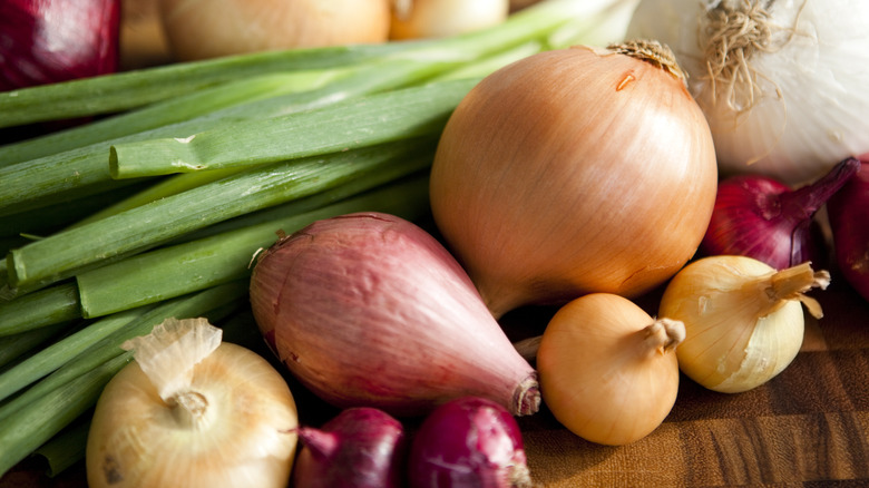 Onions and shallots on a wooden countertop