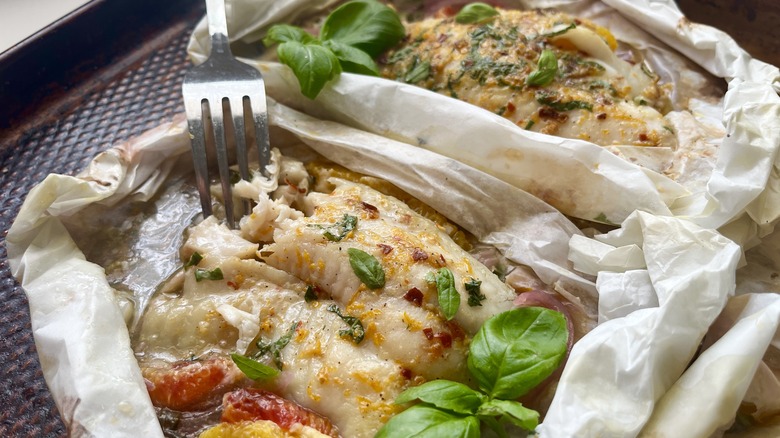 fork flaking orange basil tilapia fish baked in parchment papillote