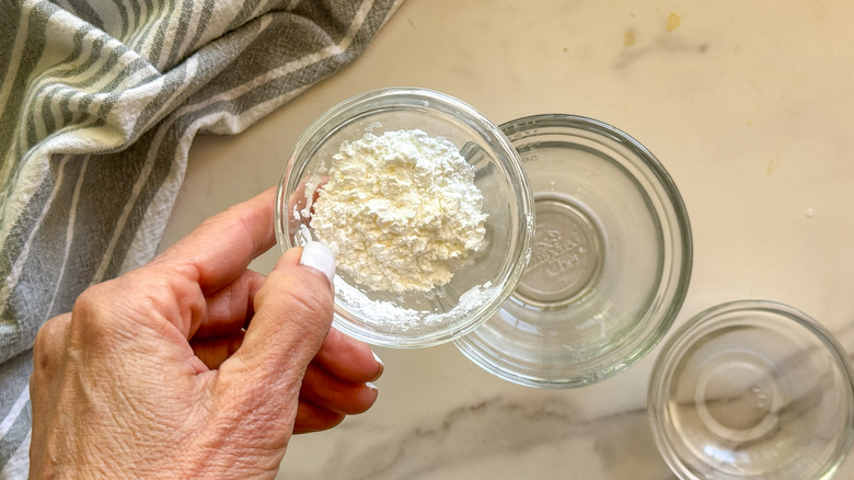 hand adding cornstarch to water