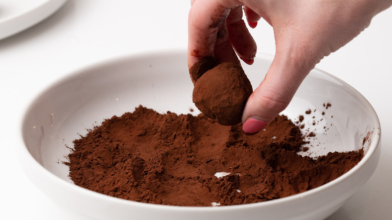 Rolling truffles in cocoa powder