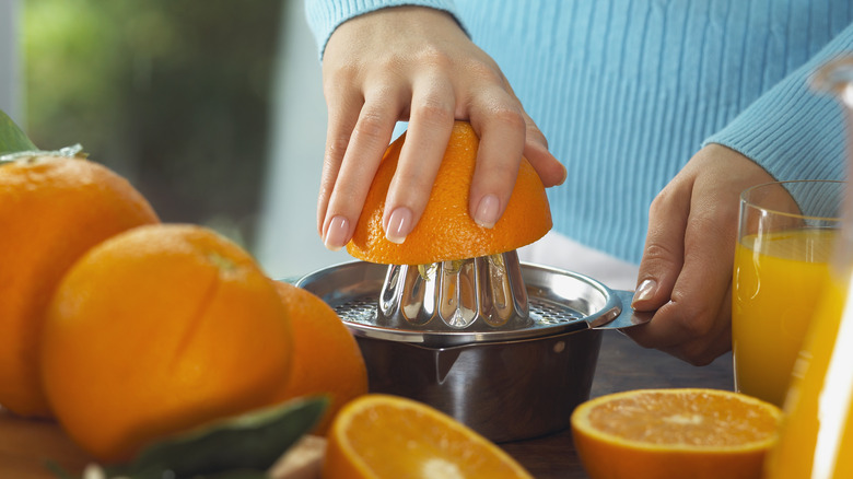 Hands juicing an orange