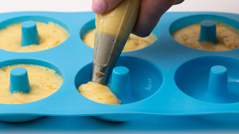 Piping batter into donut mold 