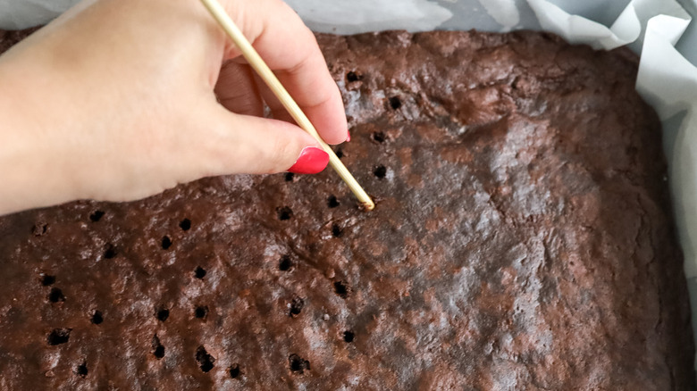 hand poking holes in brownies