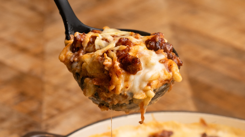 Black spoon ladling slice of mac and cheese