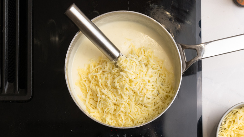 Whisking cheese into white sauce