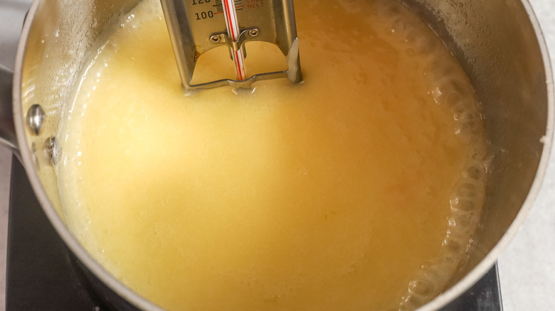 Candy thermometer inside butter mixture in pot