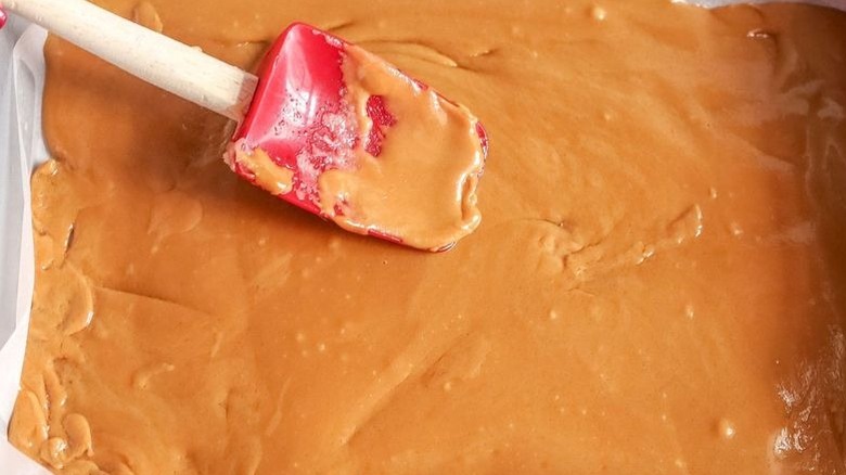 Spatula smoothing toffee out into pan