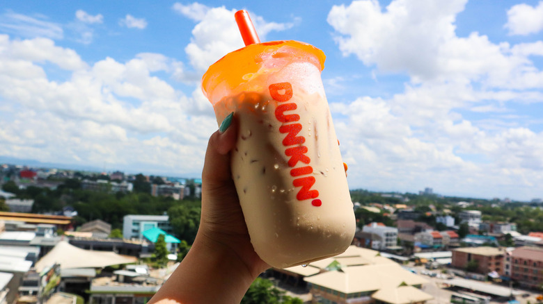 hand holding Dunkin' iced coffee