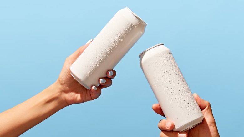 two people holding white cans