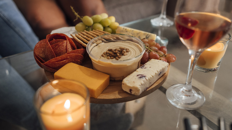 Charcuterie board, wine, and a candle