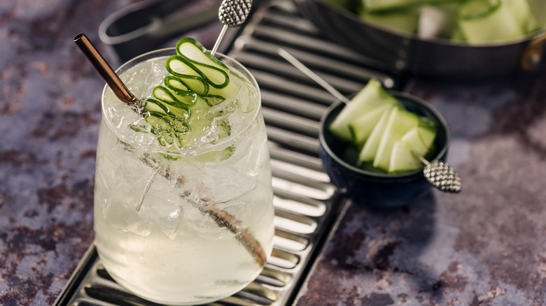 Clear drink with cucumber garnish