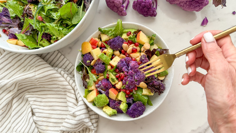 hand using fork in salad