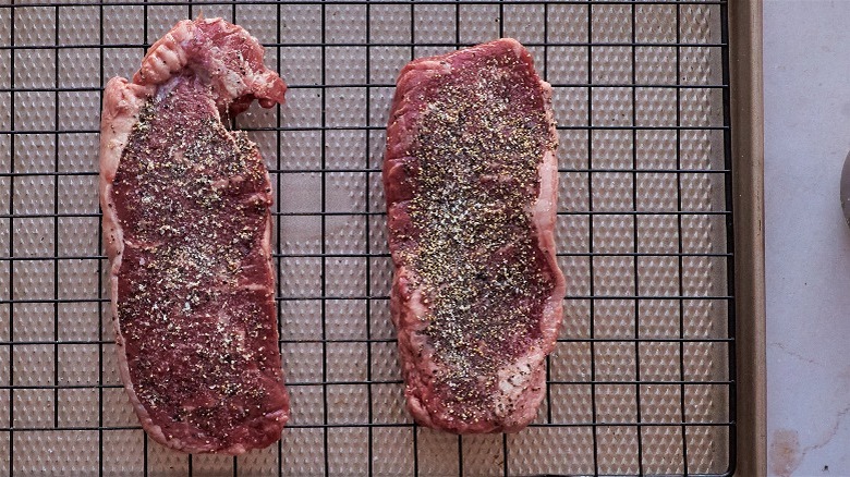 seasoned steaks on wire rack