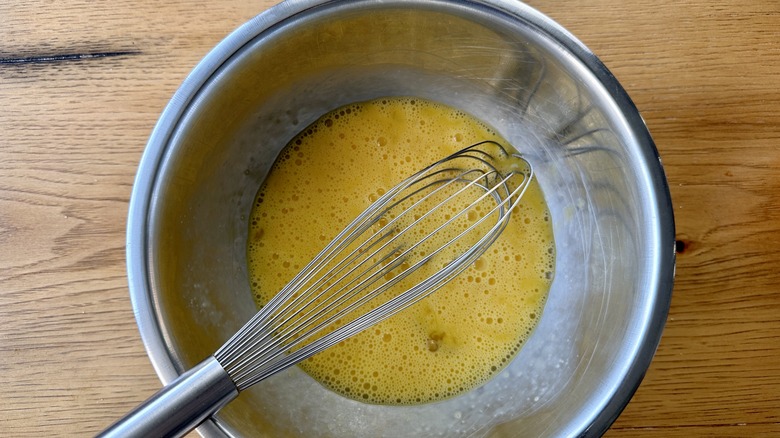 egg in metal bowl with whisk