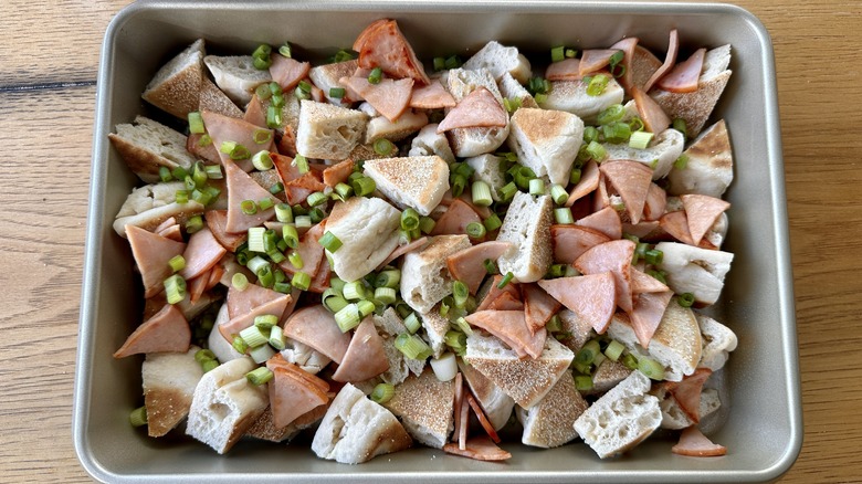 bread and canadian bacon in baking dish for breakfast casserole