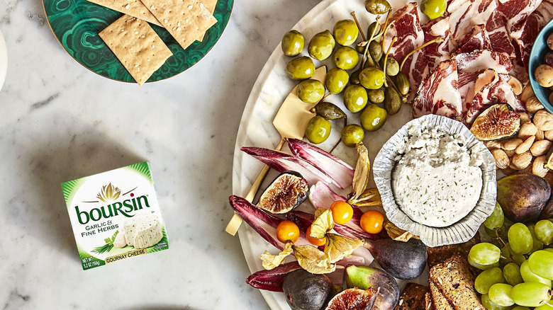 A charcuterie board featuring Boursin cheese