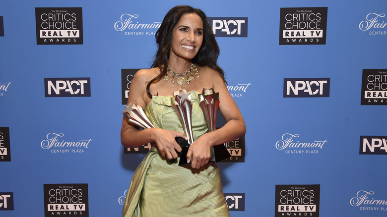 padma lakshmi holds awards in green dress