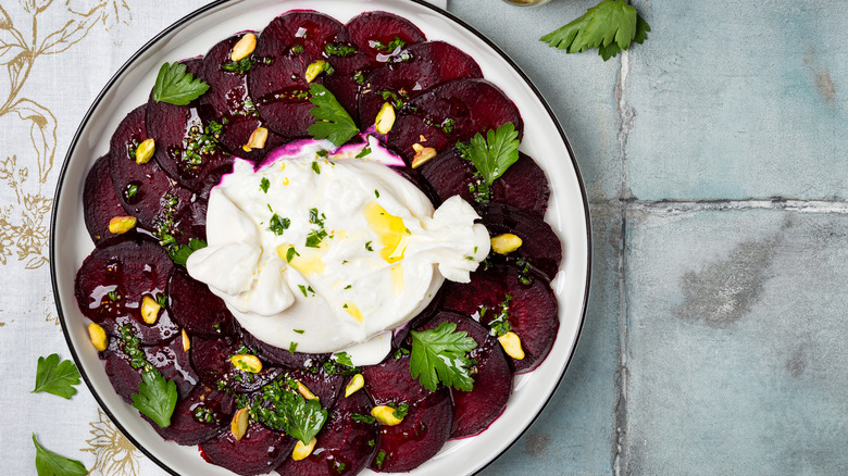 Top-down view of sliced beets with mozzarella burrata