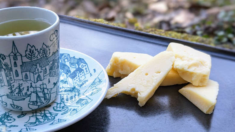 cupful of tea and plated cheese