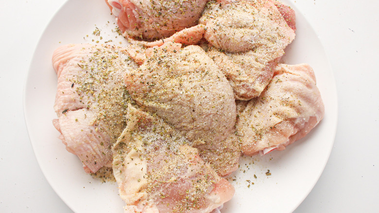 raw chicken thighs with seasoning 