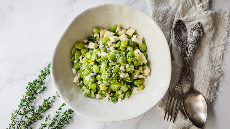 lima beans and feta in bowl with two spoons