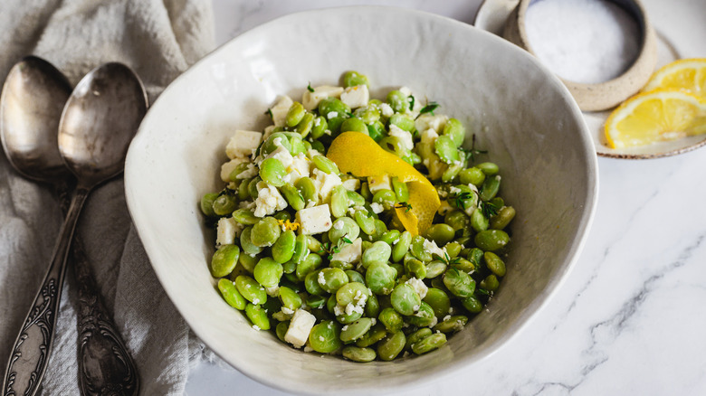 lima beans and feta in bowl with two spoons