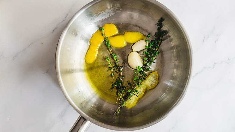 pan with oil, lemon, garlic, and thyme