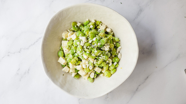 lima beans and feta in white bowl