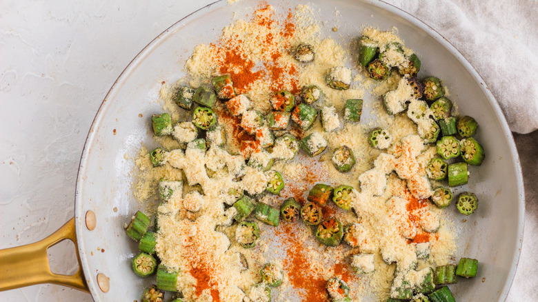 Slices of okra frying in pan with spices