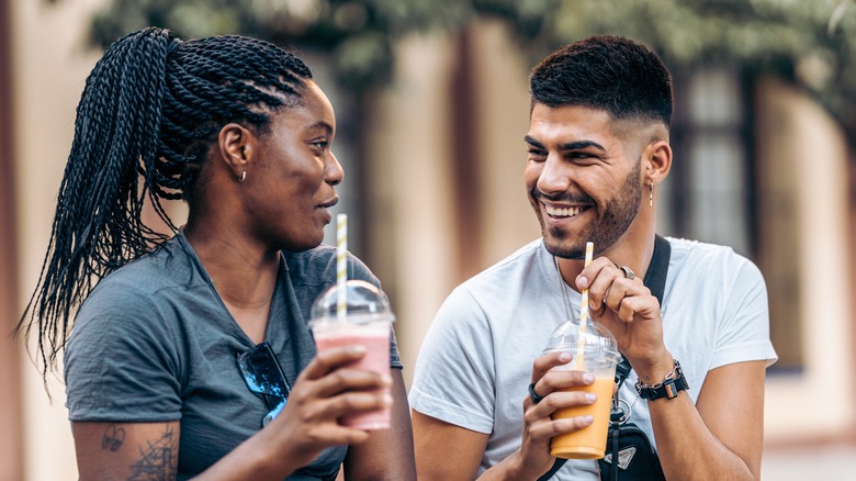 two people enjoying milkshakes