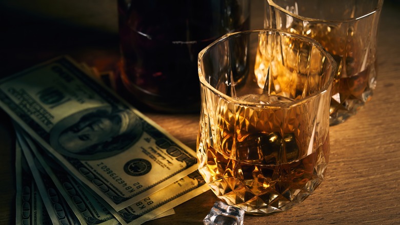 Whiskey and money on table