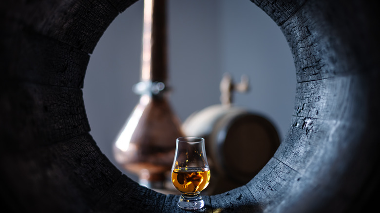 Whiskey glass in oak barrel