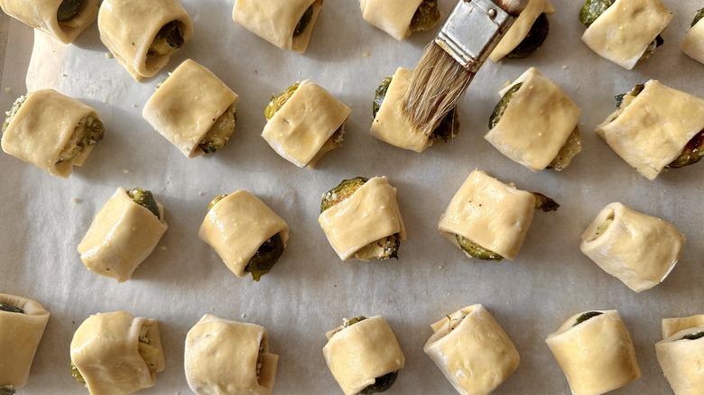 brushing pastry-wrapped sprouts with egg