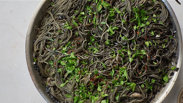 black pasta with parsley in skillet