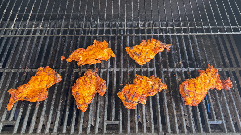 Dry-rubbed chicken thighs on grill grates
