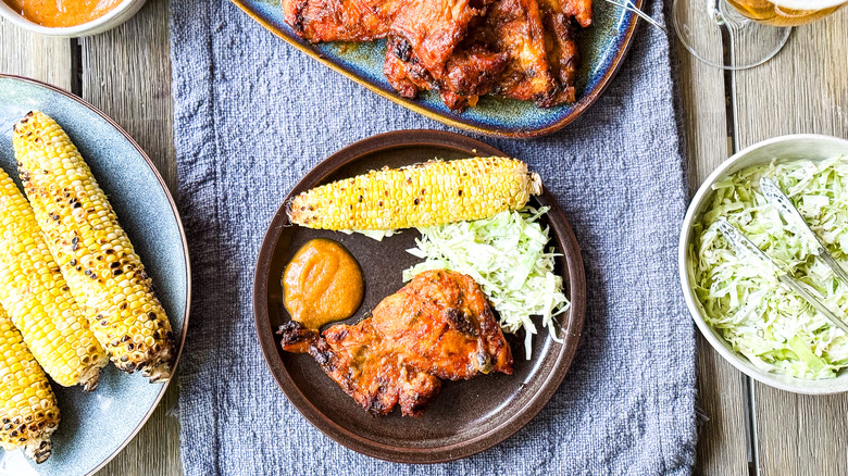Peach bbq chicken thighs with grilled corn and coleslaw