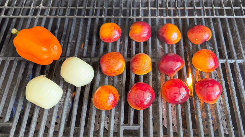 Peaches, bell pepper, and onion on gas grill grates