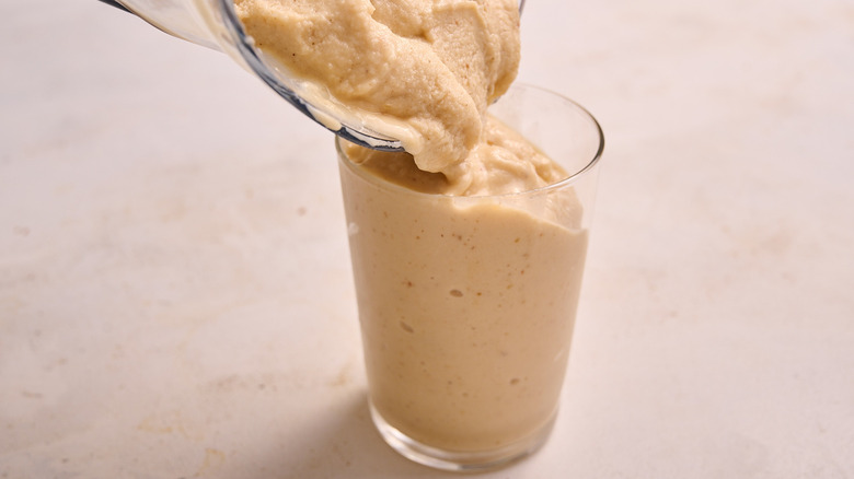 pouring smoothie into glass