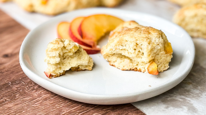 Peaches and cream scone with fresh peach slices on plate on tabletop