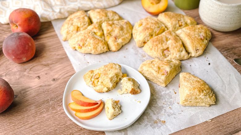 Peaches and cream scones with tea and fresh peaches on table