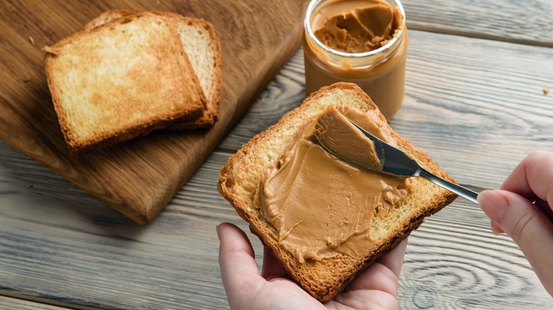 spreading peanut butter on toast