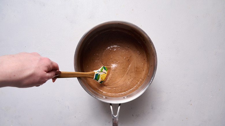 stirring pudding in saucepan