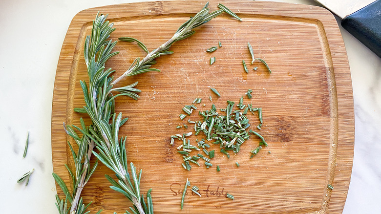 chopped rosemary on board