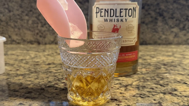 Ice being poured into Pendleton Whisky in glass