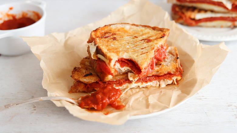 pepperoni pizza panini on plate with spoon of marinara