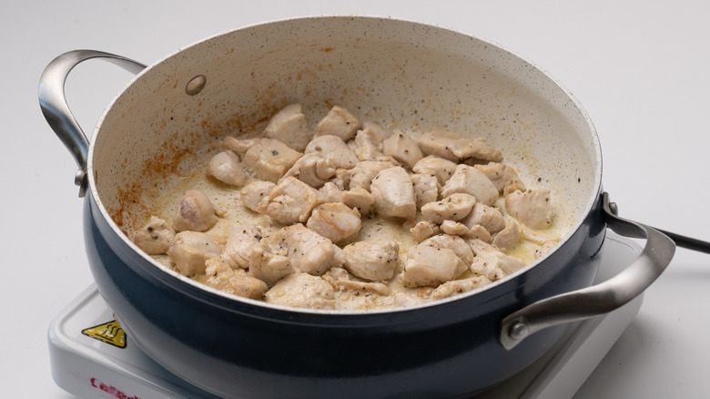 chicken frying in pan